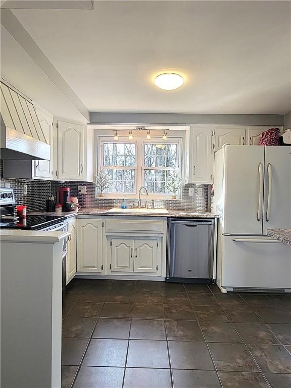 kitchen with dishwasher, white fridge, and white cabinets