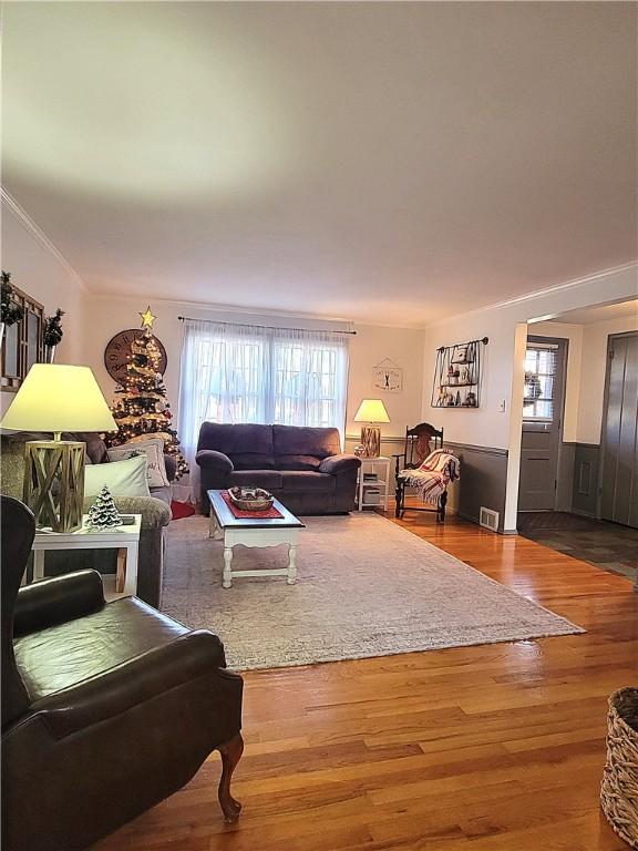 living room with hardwood / wood-style floors and crown molding