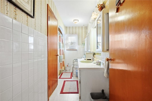 bathroom with tile patterned floors, vanity, and tile walls