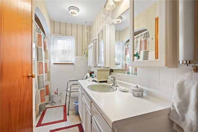 bathroom with tile patterned floors, vanity, toilet, and tile walls