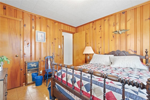 bedroom with ornamental molding and wooden walls