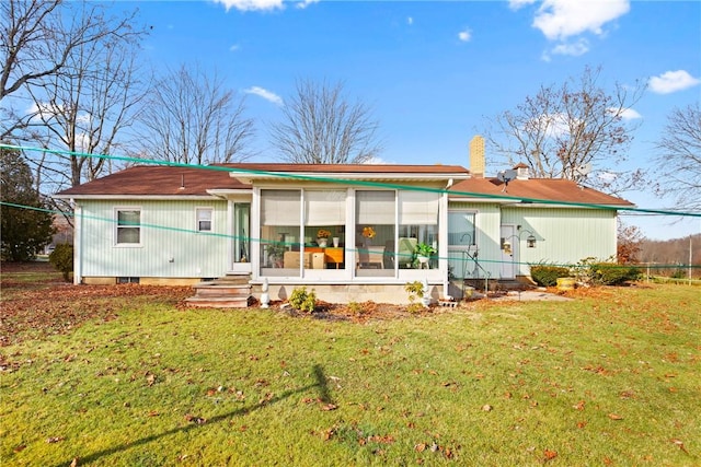 rear view of property with a lawn and a sunroom