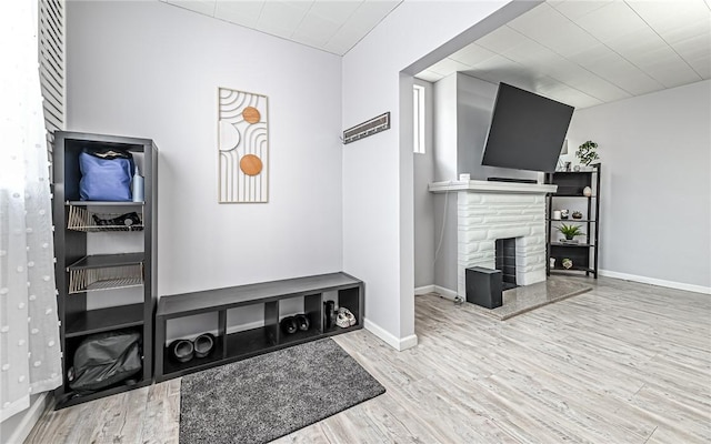 mudroom with wood-type flooring and a fireplace