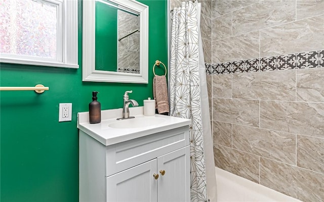 bathroom with vanity and tiled shower