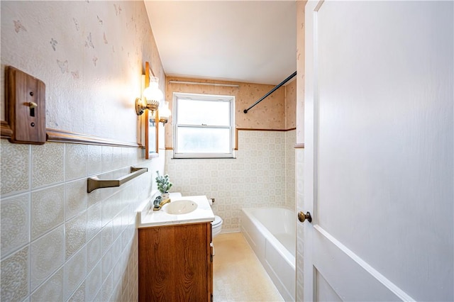 full bathroom with vanity, toilet, tile walls, and bathtub / shower combination