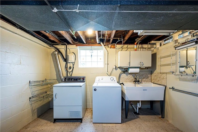 clothes washing area with washer and dryer, sink, and cabinets