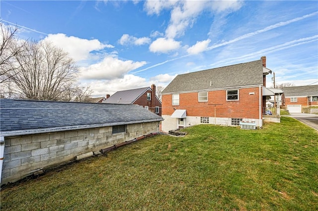 rear view of property featuring a yard and central AC