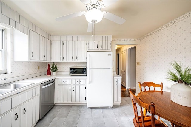 kitchen featuring white cabinets, stainless steel appliances, ceiling fan, and sink