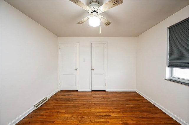 unfurnished bedroom featuring dark hardwood / wood-style floors and ceiling fan