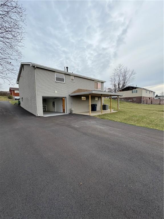 view of front of home featuring central AC unit and a front yard