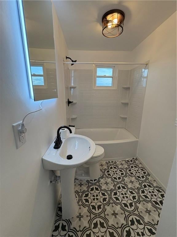 bathroom featuring tile patterned flooring, plenty of natural light, toilet, and tiled shower / bath combo