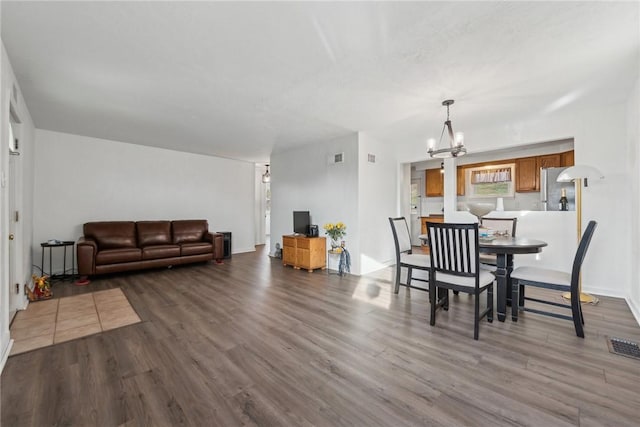 dining area featuring hardwood / wood-style flooring and an inviting chandelier