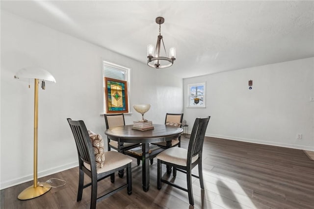 dining room featuring dark wood-type flooring and an inviting chandelier