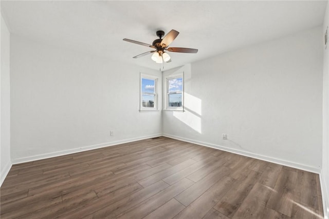 empty room with dark hardwood / wood-style flooring and ceiling fan