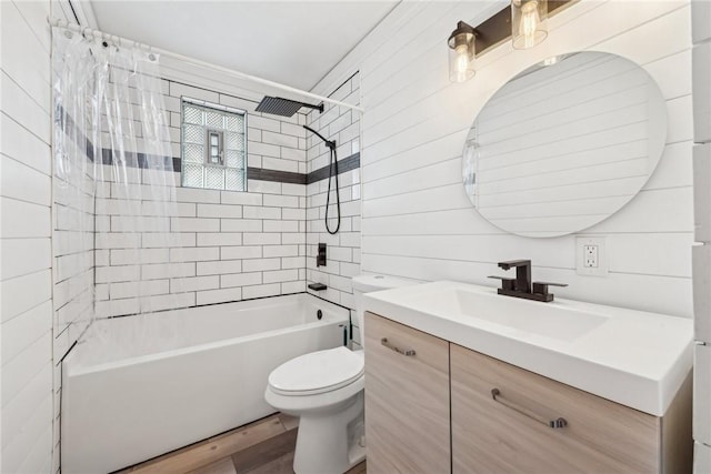 full bathroom with tiled shower / bath combo, toilet, wooden walls, vanity, and hardwood / wood-style flooring