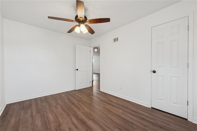 empty room featuring ceiling fan and dark hardwood / wood-style flooring