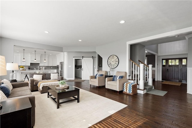 living room featuring a barn door and hardwood / wood-style floors