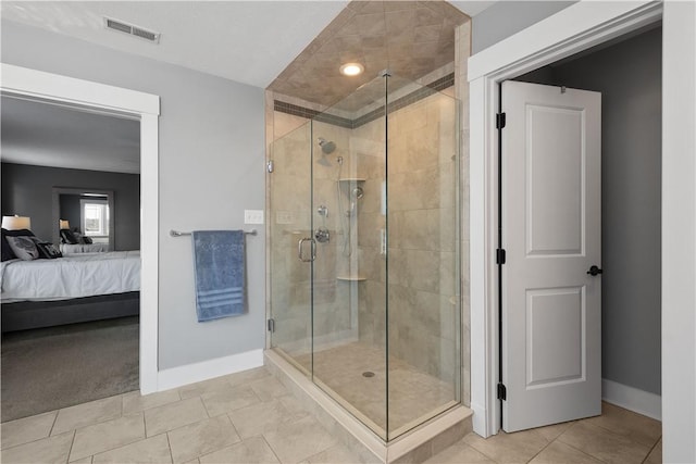 bathroom with a shower with door and tile patterned flooring