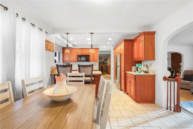 tiled dining area featuring crown molding