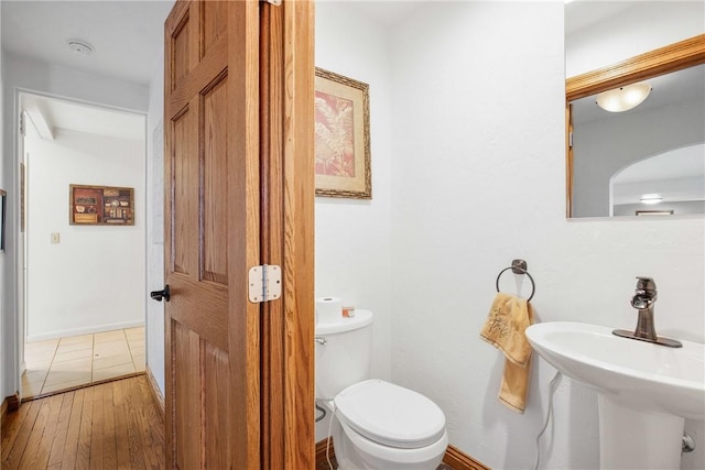 bathroom featuring hardwood / wood-style floors, toilet, and sink