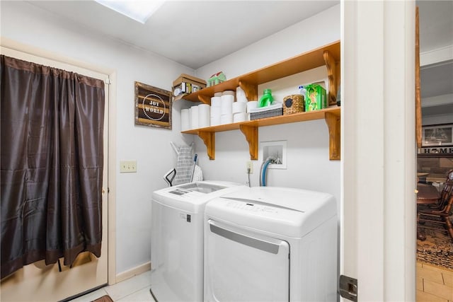 laundry room featuring washer and dryer and light tile patterned floors