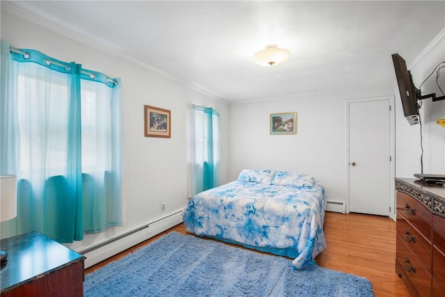 bedroom with a baseboard radiator, crown molding, and light hardwood / wood-style floors