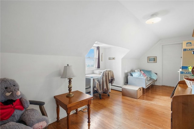 living area with hardwood / wood-style flooring, vaulted ceiling, and a baseboard heating unit