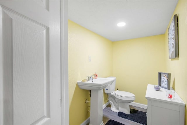 bathroom with hardwood / wood-style floors and toilet