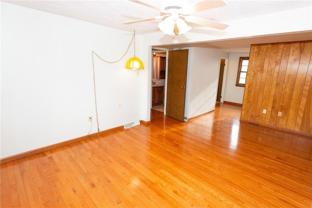 spare room featuring ceiling fan, wood-type flooring, and a textured ceiling