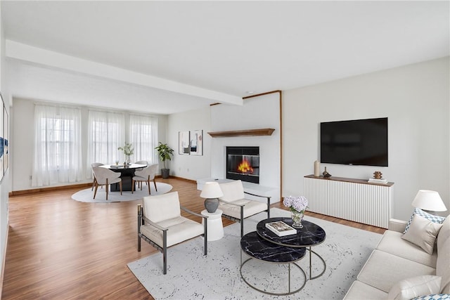 living room with beamed ceiling and light hardwood / wood-style floors