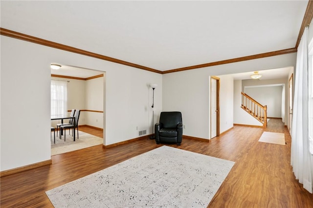 living area featuring hardwood / wood-style flooring and crown molding