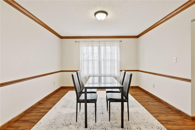 dining space featuring wood-type flooring and crown molding