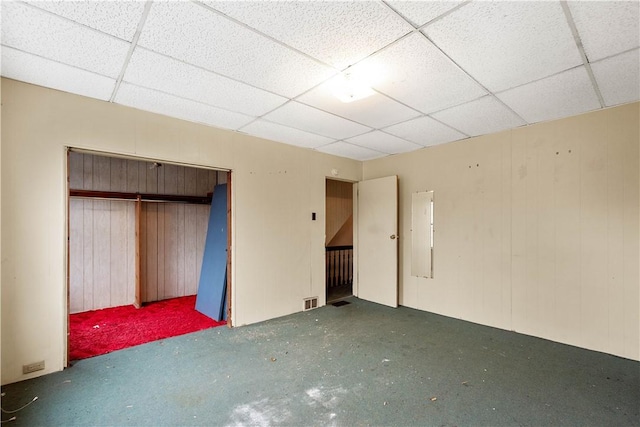 unfurnished bedroom featuring a paneled ceiling and a closet