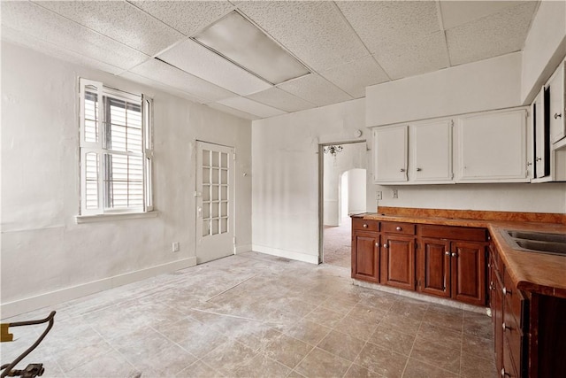 kitchen featuring butcher block countertops, a drop ceiling, and sink