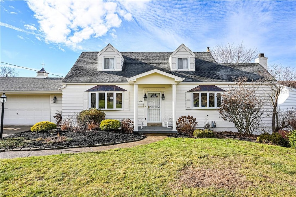 cape cod house with a garage and a front yard