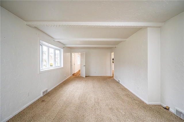 spare room with beamed ceiling and carpet