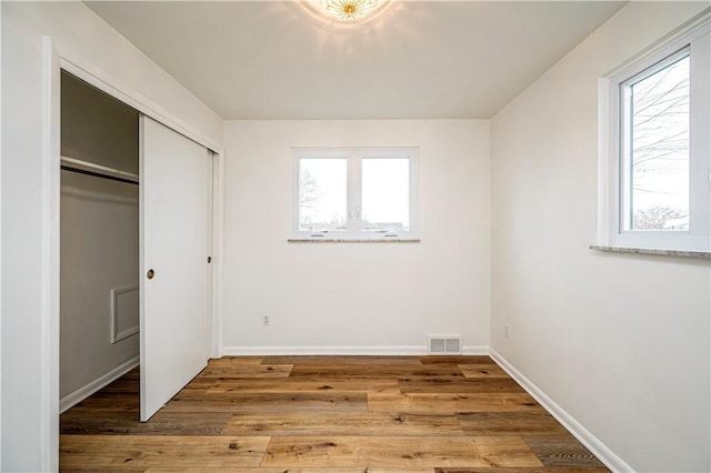 unfurnished bedroom with hardwood / wood-style flooring and a closet