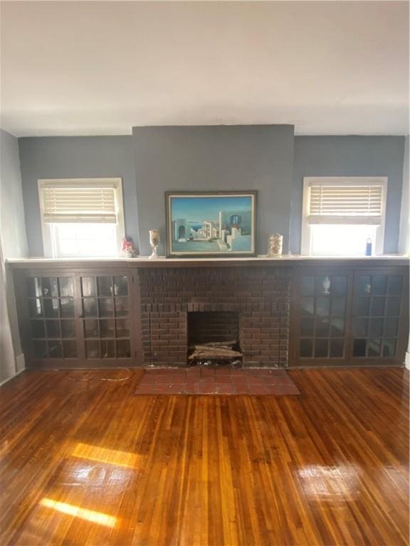 unfurnished living room featuring plenty of natural light, wood-type flooring, and a fireplace