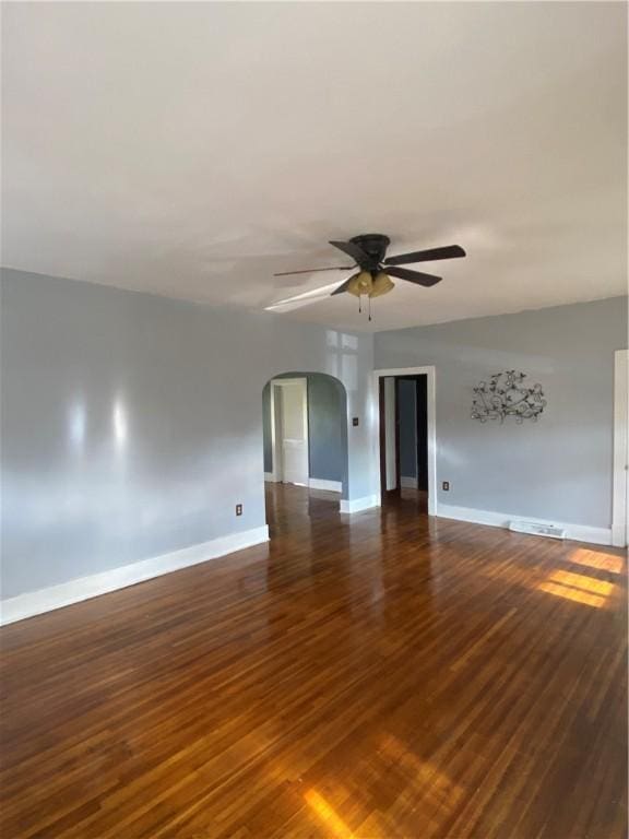 empty room featuring dark hardwood / wood-style flooring and ceiling fan