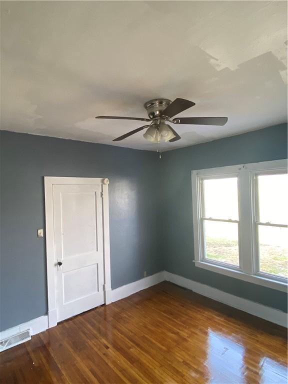 empty room with hardwood / wood-style floors and ceiling fan