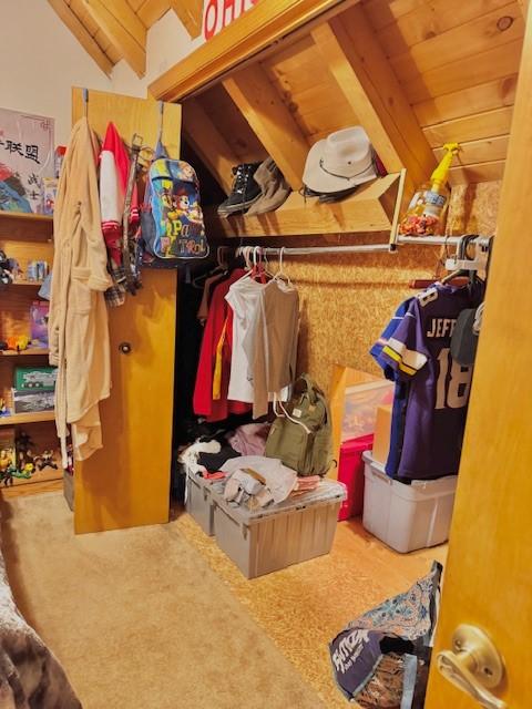 spacious closet with vaulted ceiling with beams