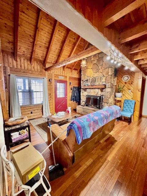 living room with hardwood / wood-style floors, a healthy amount of sunlight, wood ceiling, and wooden walls