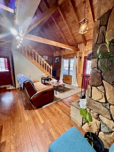 living room with hardwood / wood-style flooring, lofted ceiling with beams, plenty of natural light, and wooden ceiling