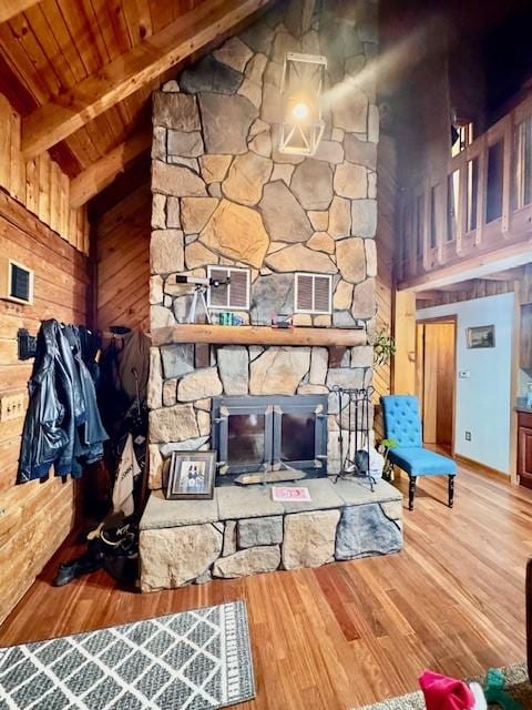 living room with beam ceiling, wooden ceiling, high vaulted ceiling, hardwood / wood-style floors, and a fireplace