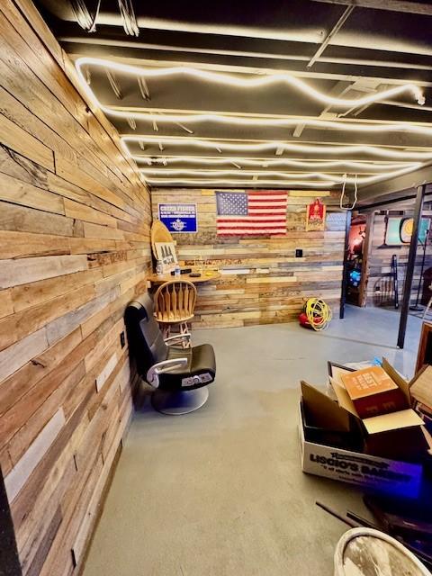 basement featuring wooden walls