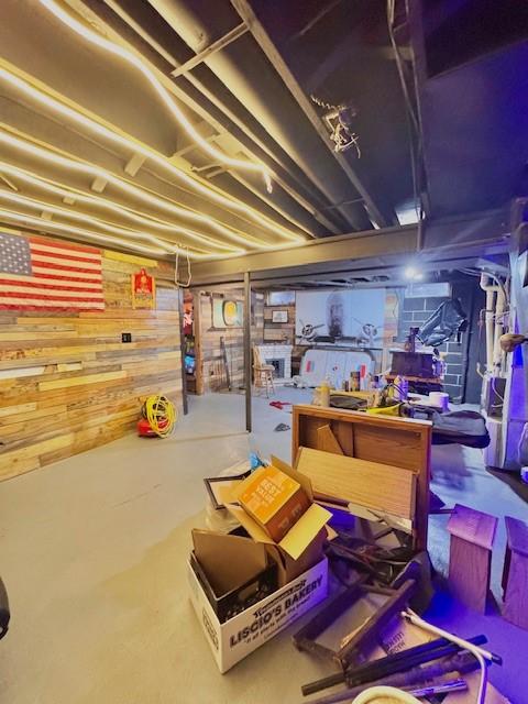 basement with a workshop area and wooden walls