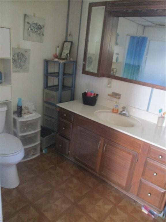 bathroom featuring vanity, parquet floors, and toilet