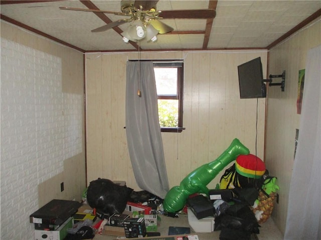 miscellaneous room with wooden walls, crown molding, and ceiling fan