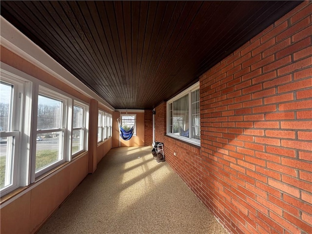 unfurnished sunroom with a wealth of natural light, lofted ceiling, and wood ceiling