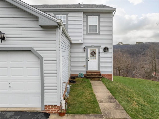 doorway to property with a yard and a garage